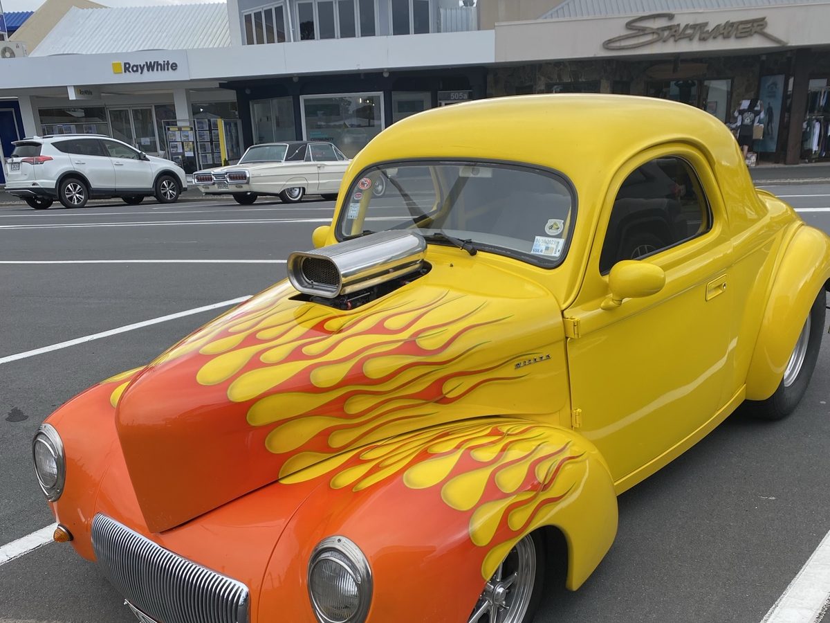 A yellow and orange flamed hot rod parked on Port Road, Whangamata